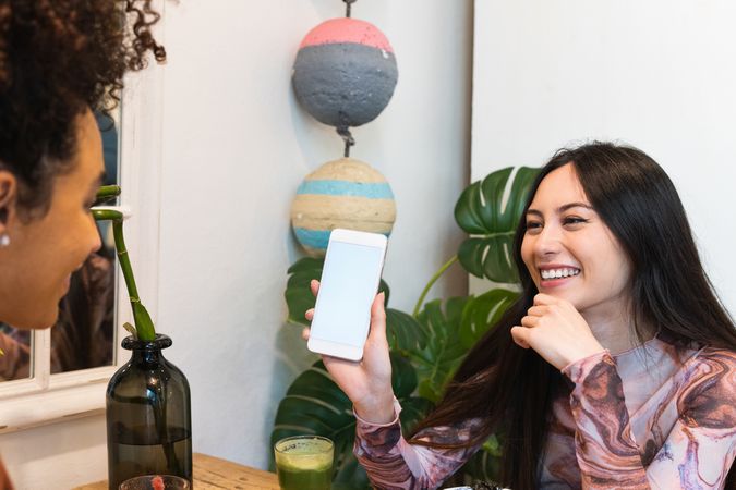 Smiling multiethnic women eating in restaurant