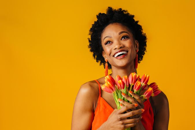 Overjoyed Black woman holding bouquet of tulips