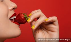 Close up of woman holding strawberry at her mouth 0W8715
