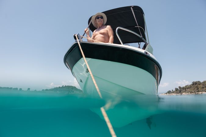 Man sailing in boat in clear turquoise water