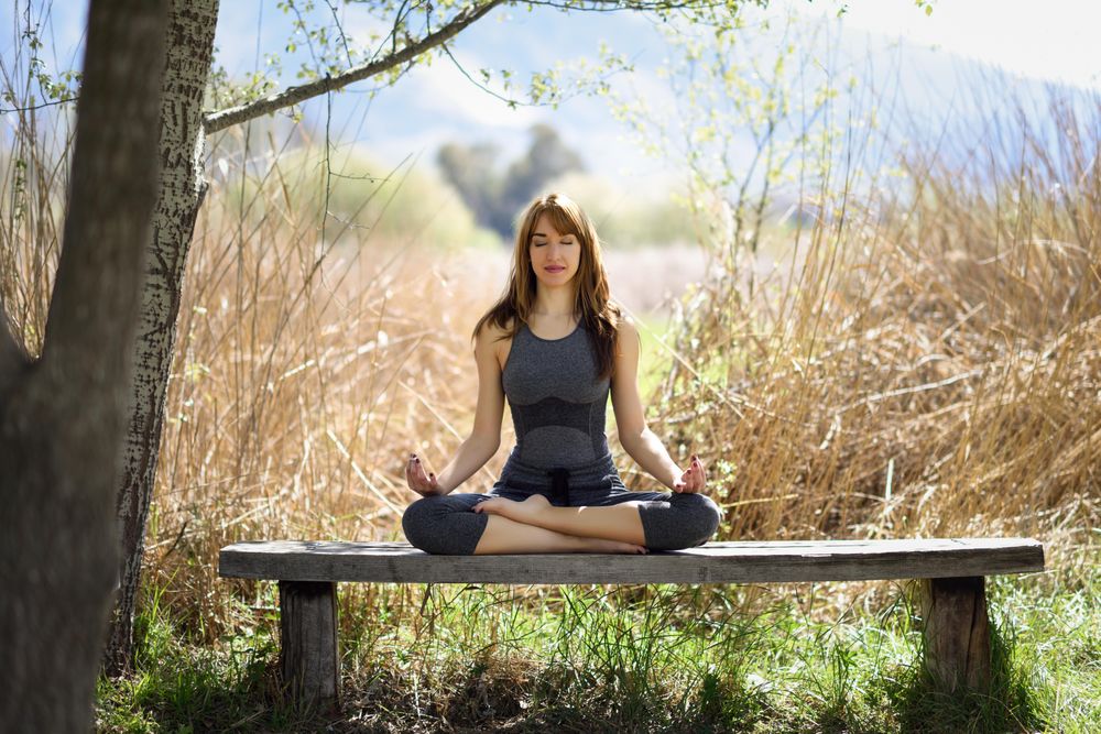 Female wearing dark sport clothes in lotus pose