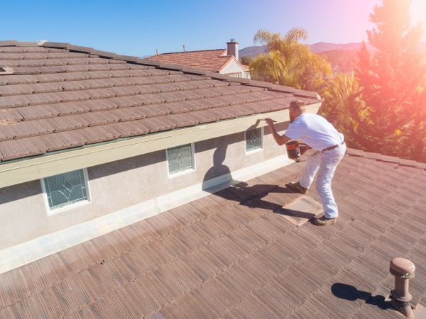 Professional Painter Using A Brush to Paint House Fascia