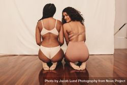 Two confident young women kneeling in underwear in studio photoshoot 0g8R75