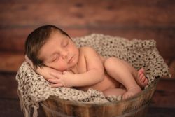Naked baby sleeping in bucket