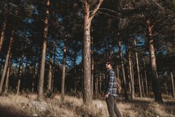 Confident tourist walking along autumn forest
