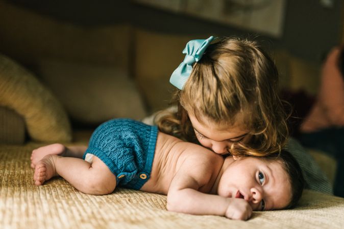 Little girl kissing baby