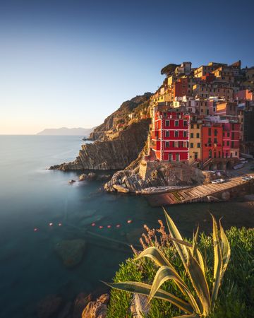 Riomaggiore town, cape and sea at sunset. Cinque Terre, Liguria, Italy