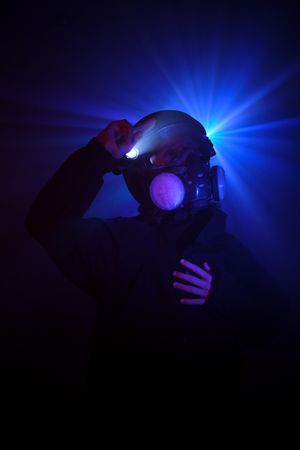 Robber in mask standing in dark studio