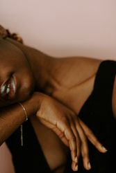 Woman in dark tank top wearing gold bracelet
