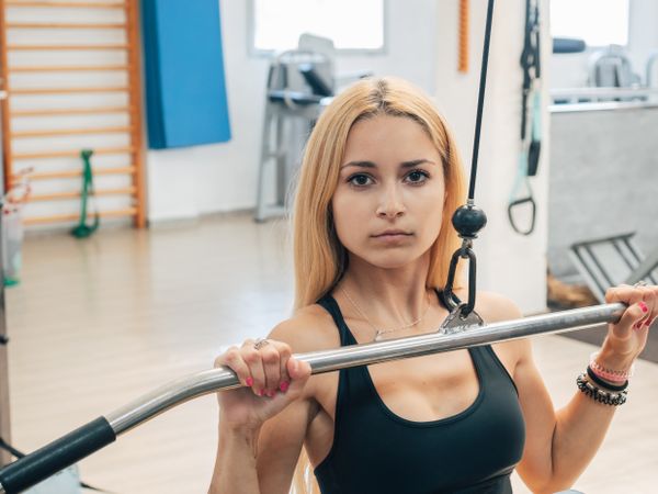 Fit woman doing lat pull-down exercise