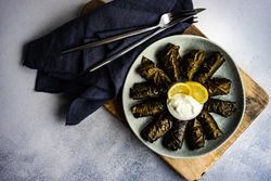 Top view of grey plate with traditional Georgian dolma dish with dip