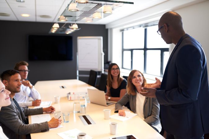 Businessman standing an leading a meeting with colleagues