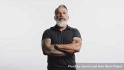 Man with tattoo on arms standing against light background 0gGRA0