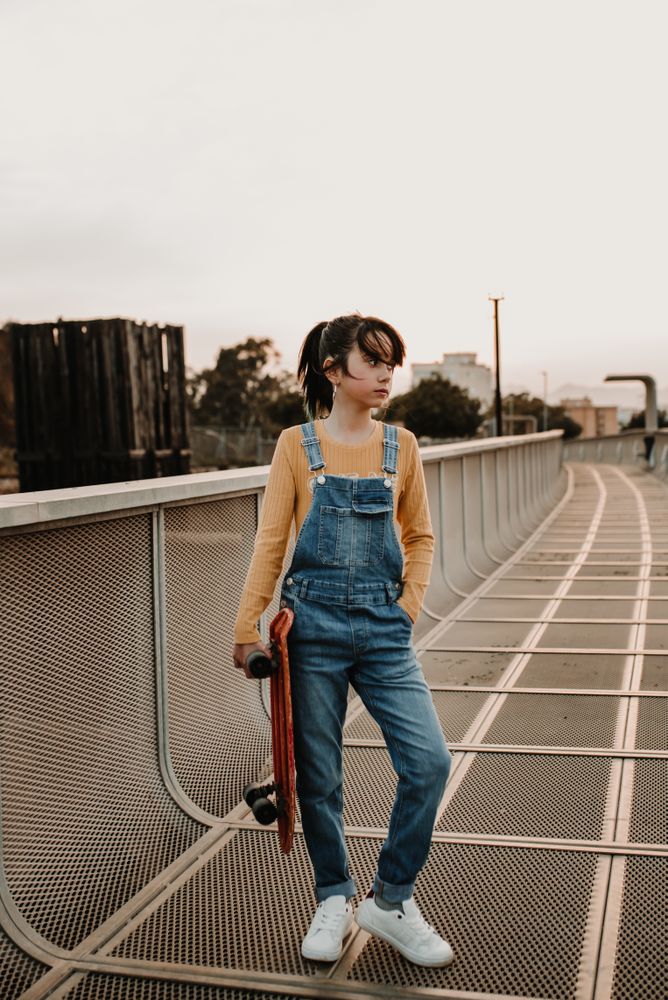 Girl with skateboard on walkway