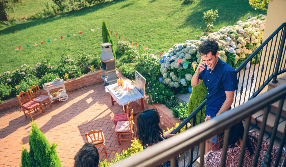 Young man calling by phone over barbecue background