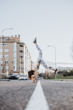 Woman doing handstand on street