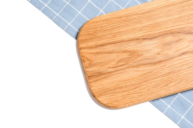 Cutting board with kitchen towel isolated on plain background, top view
