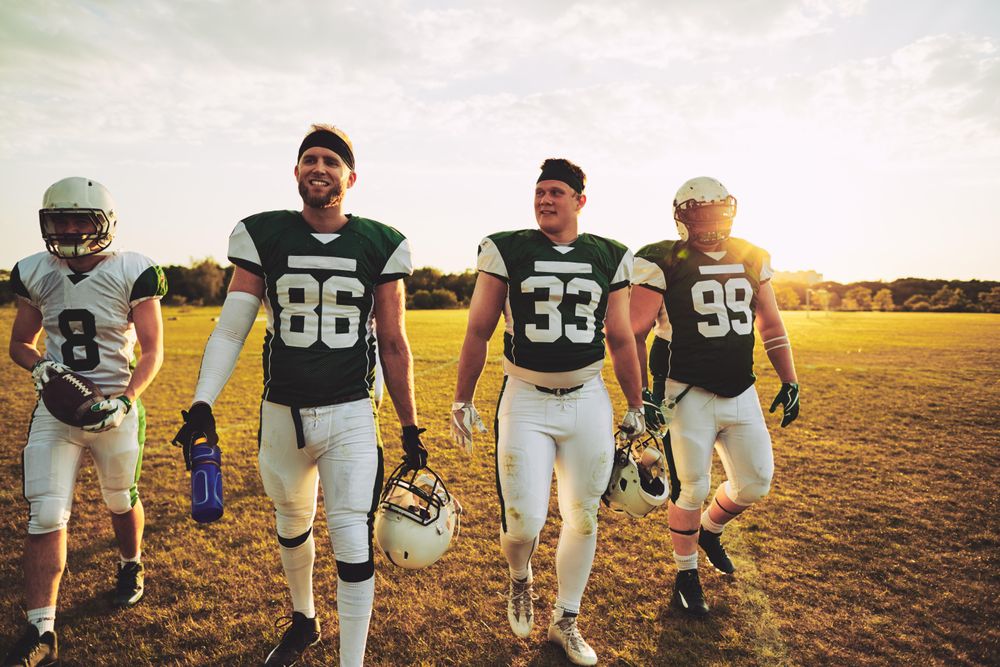 Group of men leaving the sports pitch after a game