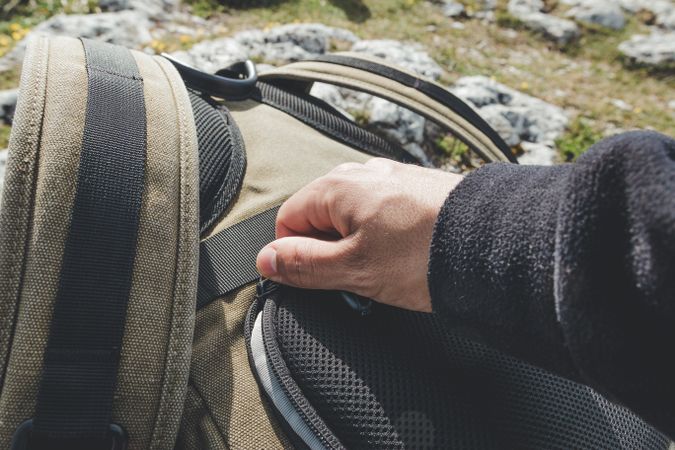 Man closing pocket of backpack