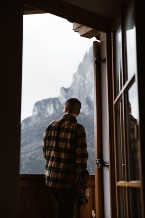 Male in casual wear standing by a window