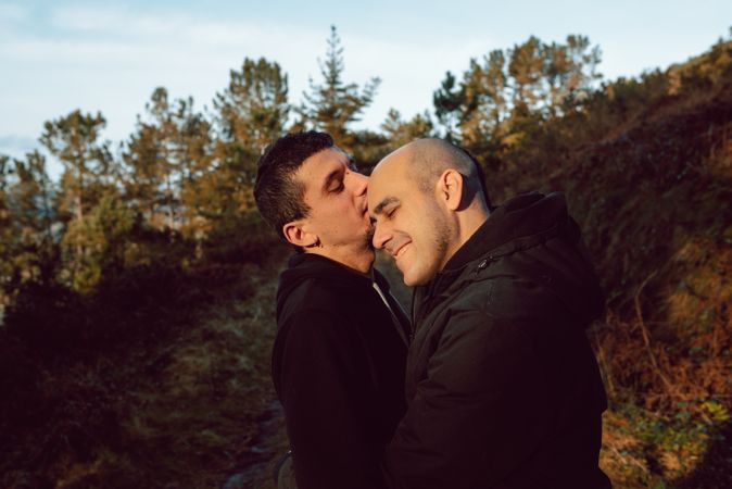 Smiling men hugging on countryside road