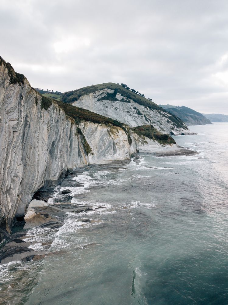 Sea waving near green hills