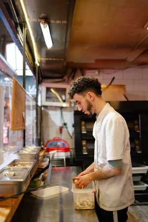 Pizza man putting ingredients in containers