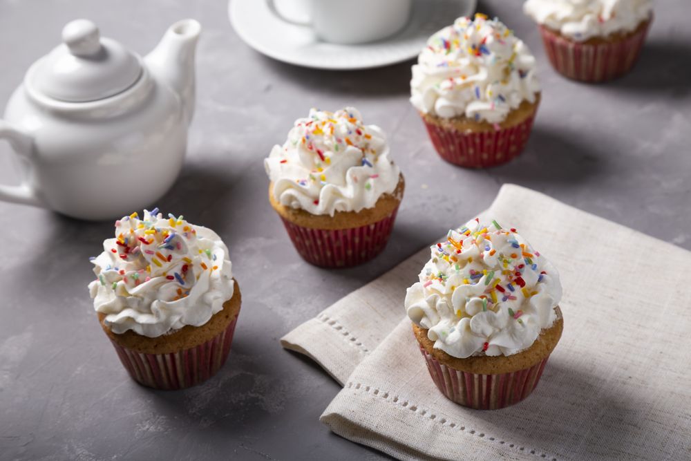 Tasty party cupcakes on the table. Cupcakes with whipped cream.