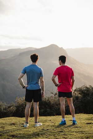 Male runners resting and enjoying mountain landscape