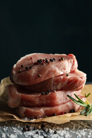 Composition with raw meat for steak and spices on wooden background
