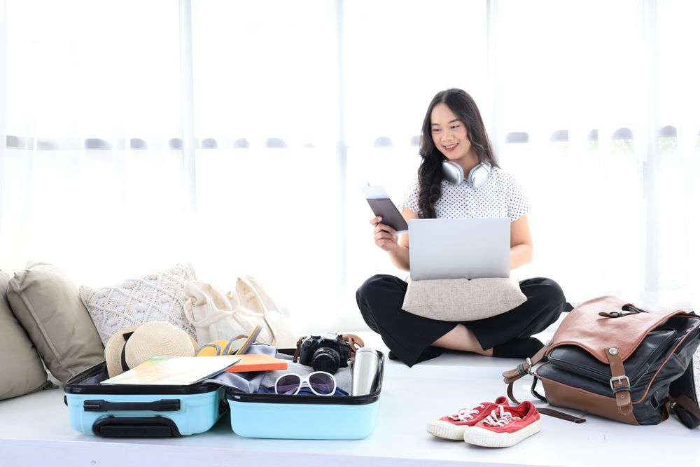 Happy female using computer to planning travel trip and booking tickets or hotel room on web.