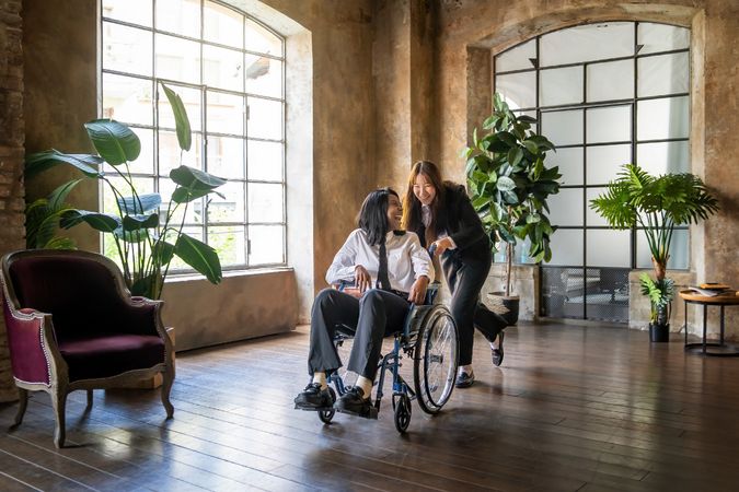 Two friends and work colleagues, one with a disability, in the office together