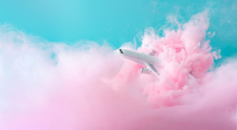 Cloud-like pink color paint with light  airplane on blue background