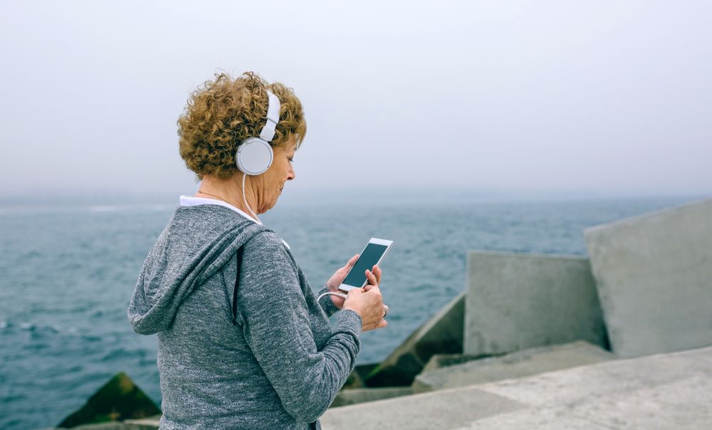 Unrecognizable Older sportswoman using her smartphone