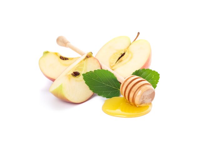 Apple pieces, leaves and dipper with honey isolated on neutral background