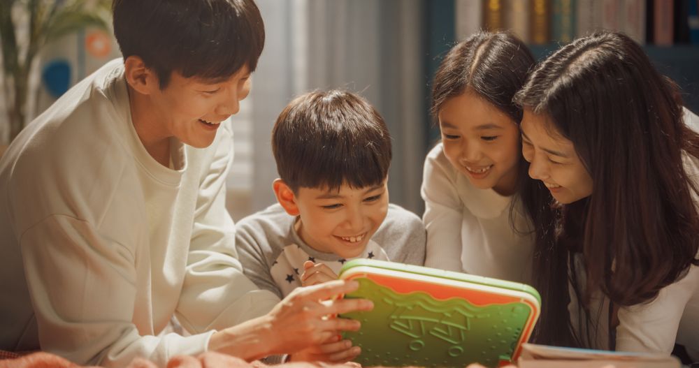 Portrait of a Couple and Kids Playing Video Games on a Digital Tablet.