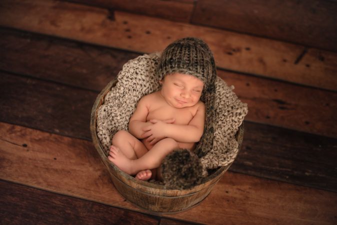 Naked baby sleeping in bucket