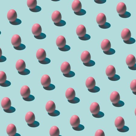 Pattern made of pink eggs on pastel blue background