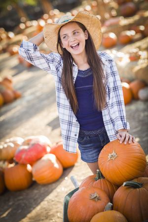Preteen Playing with a Wheelbarrow at the Pumpkin Patch.