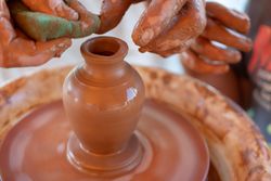 Two people making clay pottery