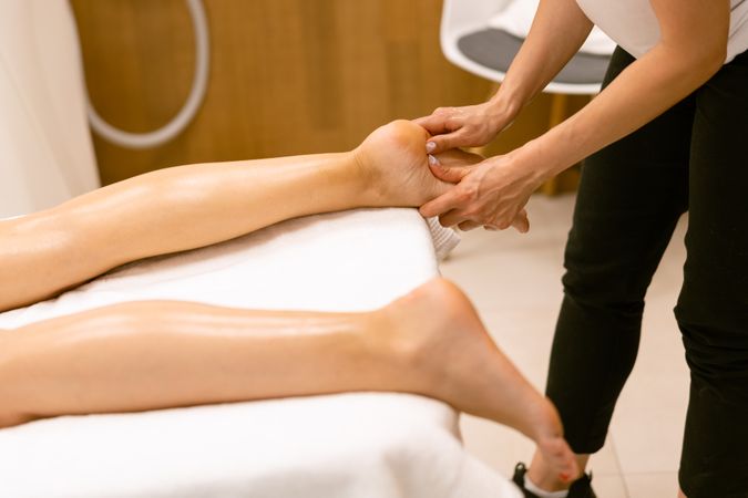 Masseuse working on a client’s feet