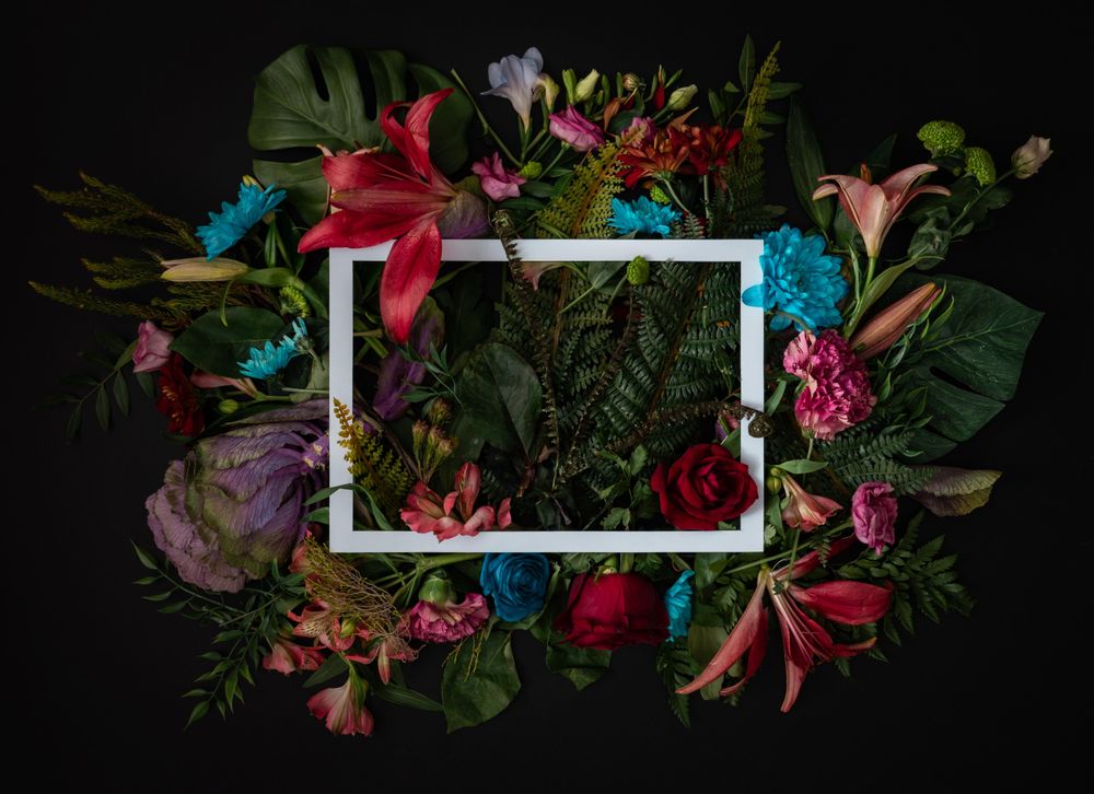 Colorful spring flowers of red, blue, pink, cream around paper square outline