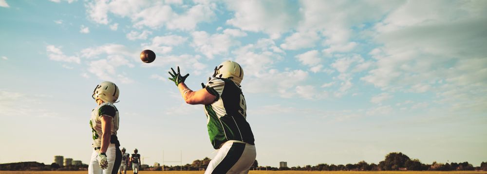 Man catches football during practice
