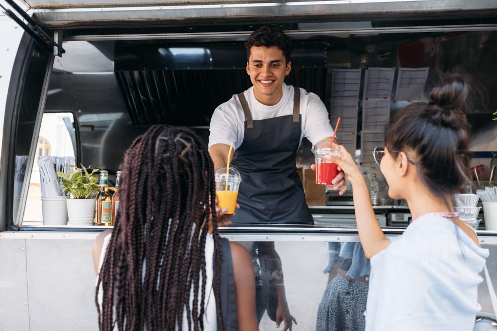 Smiling entrepreneur giving drinks to clients