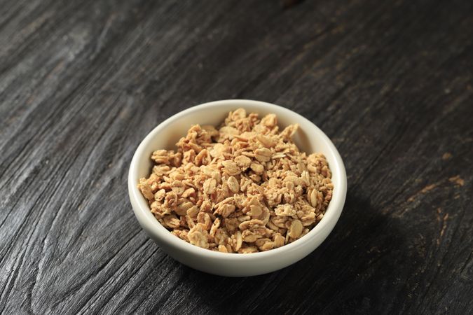 Muesli Breakfast Cereal in a Ceramic Small Bowl   above Wooden Table.
