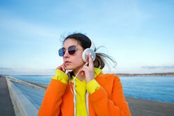 Woman with headphones on the beach