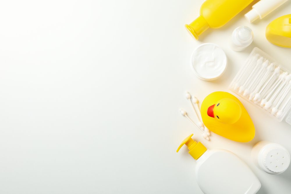 Baby hygiene accessories on light background, top view and space for text