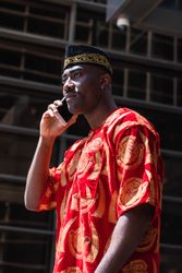 Adult male in traditional clothes talking on cellphone in street