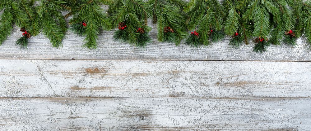 Christmas or New Year holiday background on aged wood with evergreen and red berries