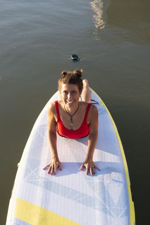 Smiling woman stretching back on paddleboard